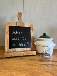 a chalkboard sign next to a pot on a table at Pension Spreewald Lächeln - Apartment Kahnfahrt durch den Spreewald in Treppendorf