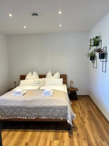 a bedroom with a bed with white walls and wooden floors at Pension Spreewald Lächeln - Apartment Kahnfahrt durch den Spreewald in Treppendorf