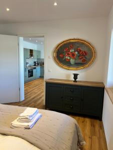 a bedroom with a painting of flowers on the wall at Pension Spreewald Lächeln - Apartment Kahnfahrt durch den Spreewald in Treppendorf +11 photos