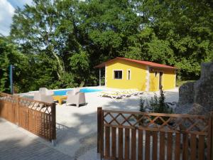 a backyard with a yellow house and a pool at Casinha de campo in Geres