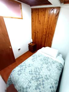 a bedroom with a bed and a wooden wall at Departamento Lido Central in El Cerrillo