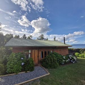 a small wooden cabin with a green roof at Cabaña Pino Oregón in Pucará