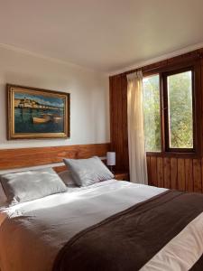 a bedroom with a large bed and a window at Cabaña Pino Oregón in Pucará