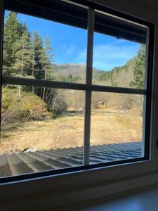 a window view of a field from a house at 2 bedroom apartment with beautiful view in Sauda +2 photos