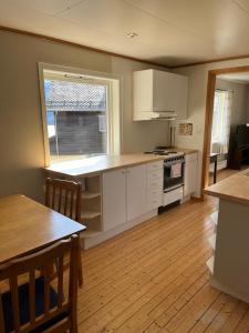 a kitchen with white cabinets and a table and a window at 2 bedroom apartment with beautiful view in Sauda