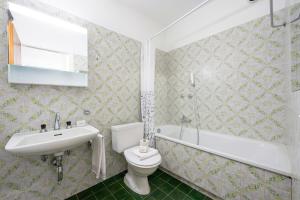 a bathroom with a toilet and a sink and a tub at Lido Apartment Locarno with Balcony and Parking - Happy Rentals in Locarno