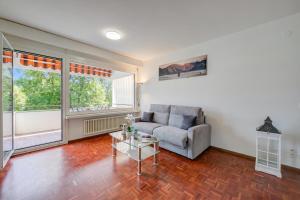 a living room with a couch and a table at Lido Apartment Locarno with Balcony and Parking - Happy Rentals in Locarno +15 photos