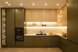 a kitchen with wooden cabinets and a sink at Luxury Pool Villa Palasea With Panoramic Sea View in Vlorë