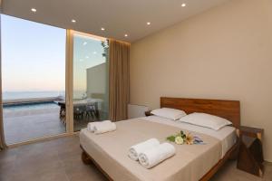 a bedroom with a large bed with towels on it at Luxury Pool Villa Palasea With Panoramic Sea View in Vlorë