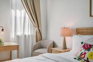 a bedroom with a bed and a chair and a desk at Casa Piccioni by Otium in San Juan