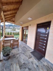 a patio with a wooden door and a table and chairs at Митровилица - Mitrovilica in Mitrovac