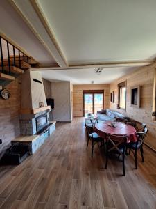a large living room with a table and a fireplace at Митровилица - Mitrovilica in Mitrovac