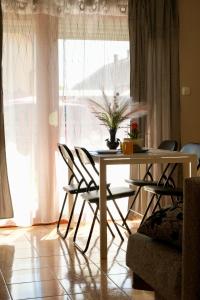 a dining room table and chairs in front of a window at Vintage Apartman Gyula in Gyula