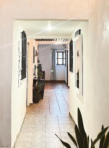 a hallway with white walls and a tile floor at La Casa de Mamapán Hotel Colonial Ahuachapan in Ahuachapán