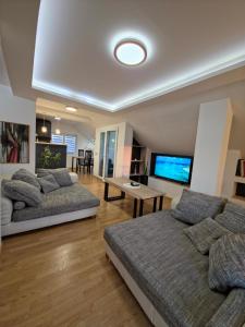 a living room with two beds and a flat screen tv at Sense Loft in Leskovac