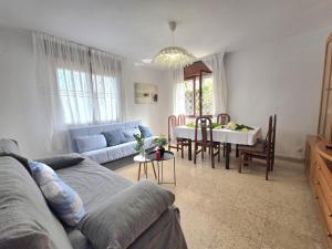 a living room with a couch and a dining room at Apartamento El Hayedo 20808 in Argoños +9 photos