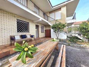 a patio with a wooden bench in front of a building at Apartamento El Hayedo 20808 in Argoños