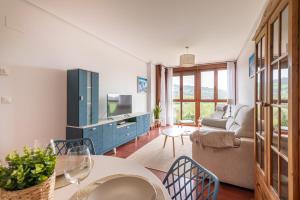 a living room with a blue cabinet and a tv at Apartamento en Bádames in Bádames