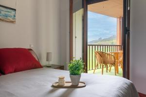 a bedroom with a bed and a view of a balcony at Apartamento en Bádames in Bádames