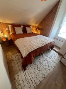 a bedroom with a large bed and a rug at Les Trois Mouettes - Grand appartement familial in Saint-Brieuc