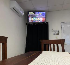 a room with a table and a television on the wall at Casa Daia con cochera y piscina in Resistencia