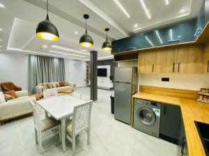 a kitchen and living room with a table and a stove at Villa SAM in Fafou