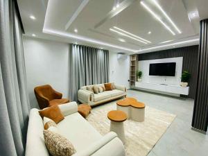 a living room with white furniture and a flat screen tv at Villa SAM in Fafou