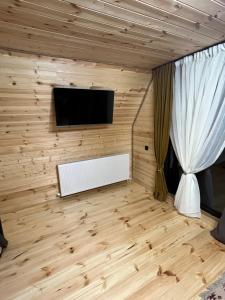 a room with a tv and a white curtain at LizMari in (( Gergeti ))