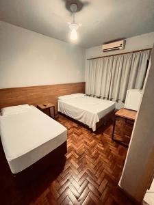 a room with two beds and a window at Hotel América in Ivaiporã