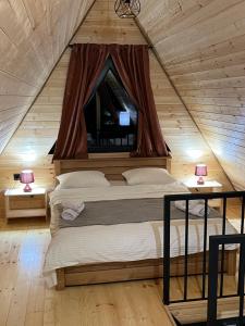a bedroom with two beds in a wooden house at LizMari in (( Gergeti ))