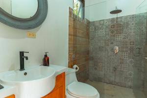 a bathroom with a sink and a toilet and a shower at Selvática Residences in Puerto Viejo +45 photos