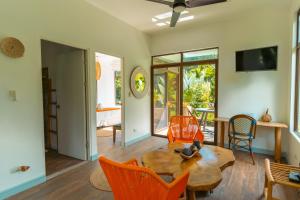 a living room with a wooden table and orange chairs at Selvática Residences in Puerto Viejo
