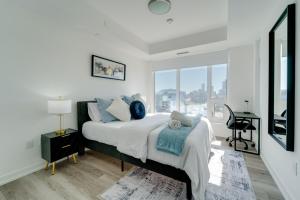a bedroom with a bed with a desk and a window at Modern Downtown Condo with Gym in Kitchener