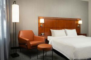 a hotel room with a bed and a chair at Courtyard by Marriott Albuquerque Airport in Albuquerque