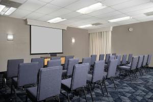 a conference room with chairs and a white screen at Courtyard by Marriott Albuquerque Airport in Albuquerque