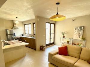 a living room with a couch and a kitchen at Maison Maragelie in Westhoffen