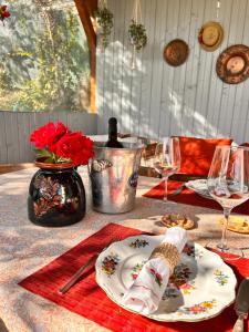 a table with a plate and a bottle of wine at Backyard Cottage in Răhău +22 photos