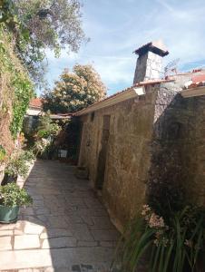 a stone house with a brick wall and a chimney at Casa da Maria Gata in Sever do Vouga