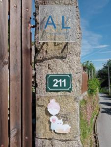 a sign on the side of a stone wall with an al sign at Casa da Maria Gata in Sever do Vouga