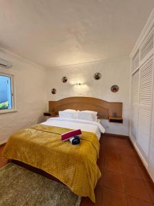 a bedroom with a bed with a red object on it at Casa Gatu Verdi-Garden Apartment with Pool in Carvoeiro +51 photos