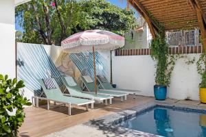 a group of chairs and an umbrella next to a pool at Casa Piccioni by Otium in San Juan