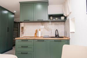 a kitchen with green cabinets and a sink at Apartmani Kostic in Tivat