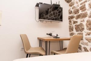 a room with a table and a tv on the wall at Apartmani Kostic in Tivat