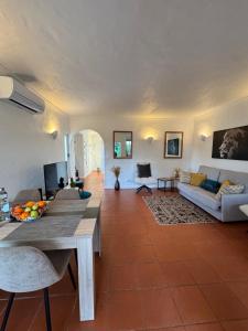 a living room with a table and a couch at Casa Gatu Verdi-Garden Apartment with Pool in Carvoeiro