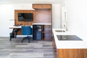 a kitchen with a desk and a table and a tv at Central Phoenix Hotel in Phoenix
