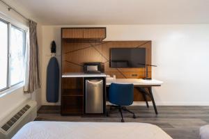 a room with a desk with a computer and a tv at Central Phoenix Hotel in Phoenix