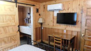 a room with a television and a table and a bed at Historic Matewan House Lodging in Matewan