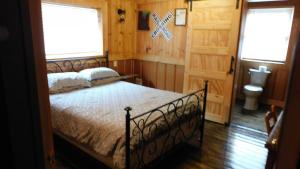 a bedroom with a bed and two windows and a toilet at Historic Matewan House Lodging in Matewan
