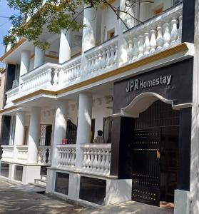 a man sits on the balcony of a building at JPR Heritage Villa in Pondicherry