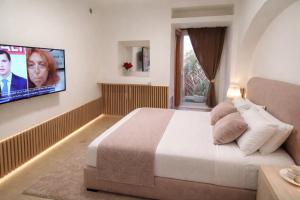 a bedroom with a bed and a flat screen tv at Affittacamere Silvagni in Caserta